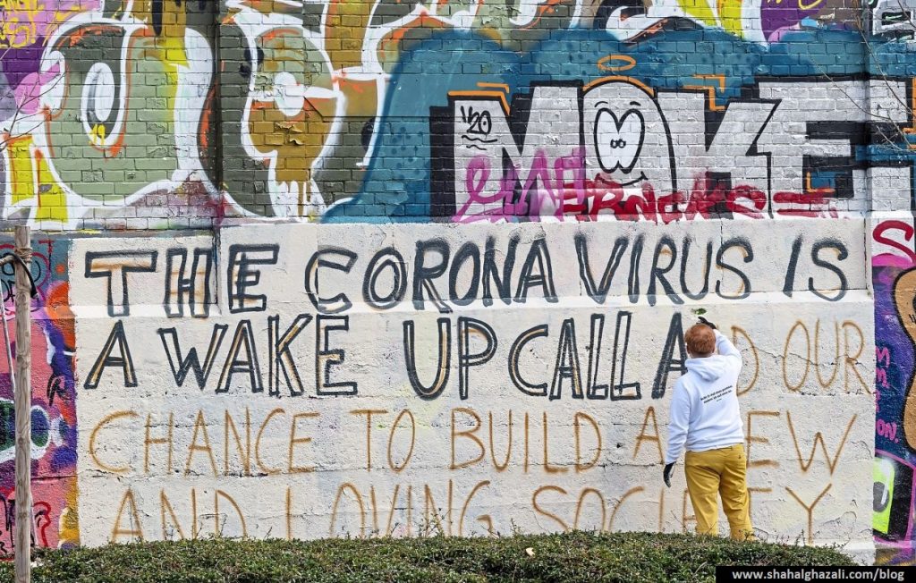 Art student Gregory Borlein prepares his graffito with the inscription "The Corona Virus is a wake up call and our chance to built a new and loving society" on a wall in the slaughterhouse district in Munich, Germany, Saturday, March 14, 2020. Only for most people, the new coronavirus causes only mild or moderate symptoms, such as fever and cough. For some, especially older adults and people with existing health problems, it can cause more severe illness, including pneumonia.